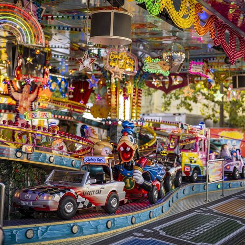 Das Fahrgeschäft Orient-Express. Ein Mädchen und ein Junge sitzen in einem der Fahrzeuge des Karussells.