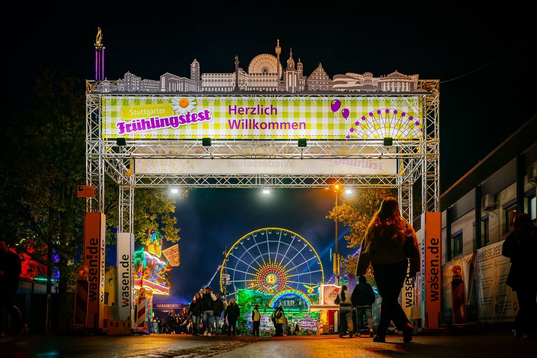 Das Eingangstor des Stuttgarter Frühlingsfestes beleuchtet bei Nacht.