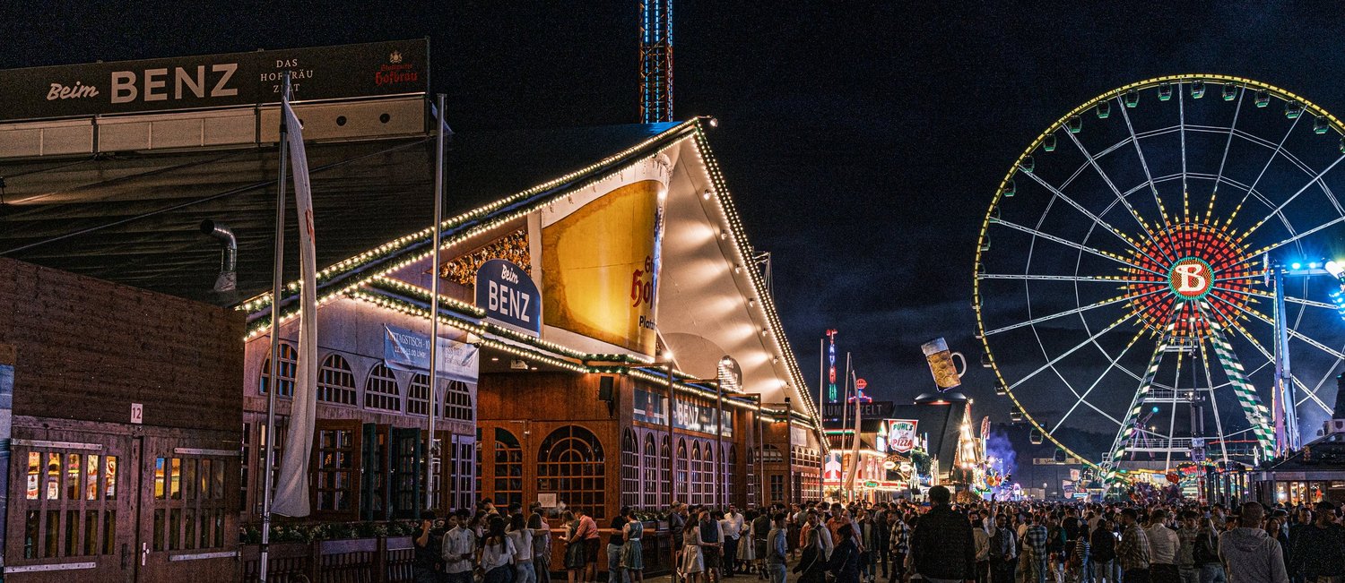 Das Festzedlt "Beim Benz" von außen, bei Dunkelheit. Im Hintergrund steht das beleuchtete Riesenrad