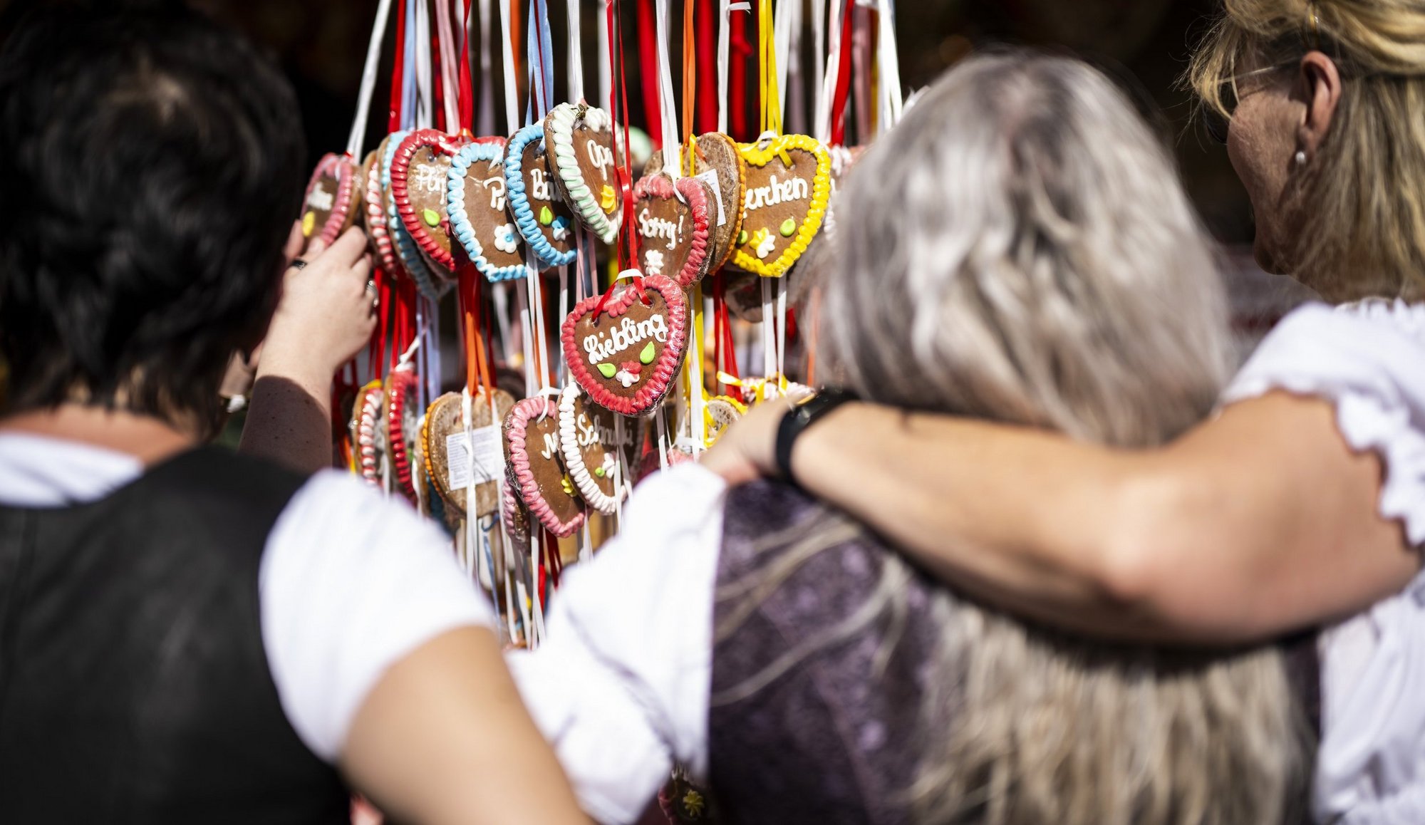 Verschiedene Lebkuchenherzen hängen an einem Stand auf dem Frühlingsfest.