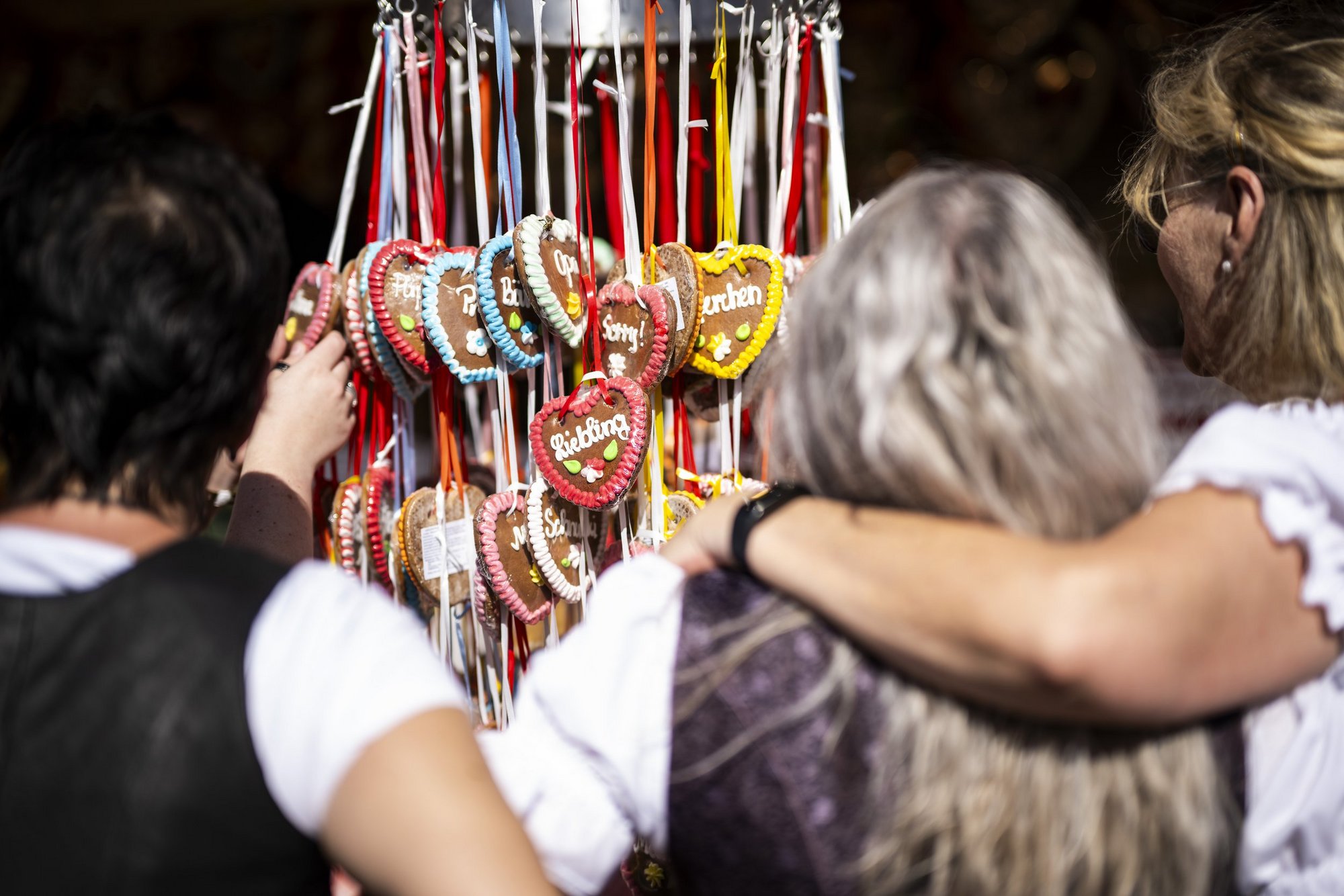 Verschiedene Lebkuchenherzen hängen an einem Stand auf dem Frühlingsfest.