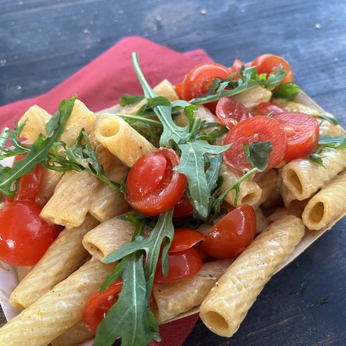 Pasta aus dem Käseleib mit Rucola und Tomaten