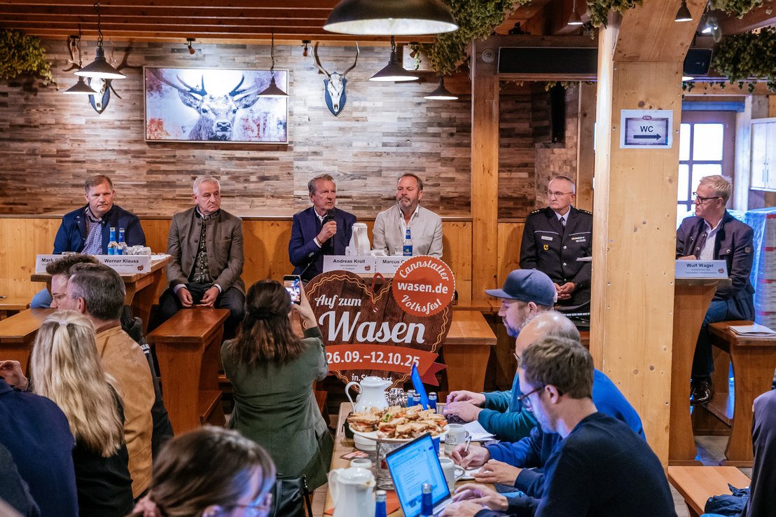 Eröffnungspressekonferenz im Dinkelacker-Festzelt Klauss und Klauss. Die Sprecher sitzen an mehreren Tischen. Von links nach rechts: Mark Roschmann - Sprecher der Schausteller, Werner Klauss - Sprecher der Festwirte, Andreas Kroll - Geschäftsführer der in.Stuttgart, Marcus Christen - Abteilungsleiter der in.Stuttgart, Jörg Schiebe - Leiter des Polizeireviers Bad Cannstatt und Wulf Wager vom Volksfestverein