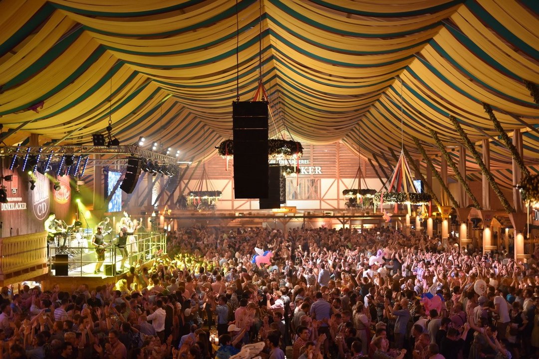 Blick durch das Festzelt von oben. Man sieht unzählige Menschen im Zelt feiern.