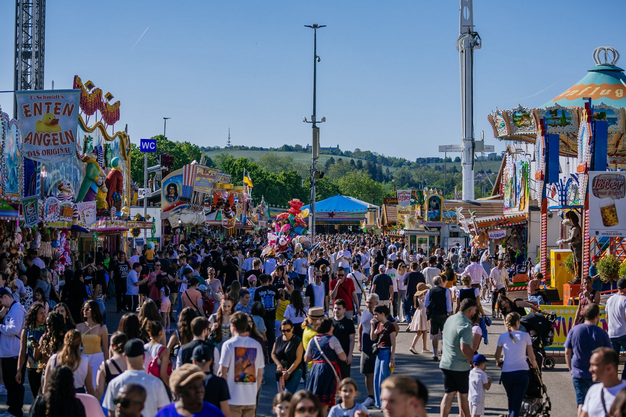 Overview of a festive street with many stalls on either side and lots of people. Overview of a festive street with many stalls on either side and lots of people.