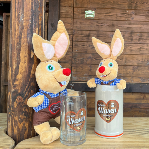 Zwei Plüsch-Hasen, einer mit einem Glas-Bierkrug in der Hand, der andere sitzt in einem Tonkrug