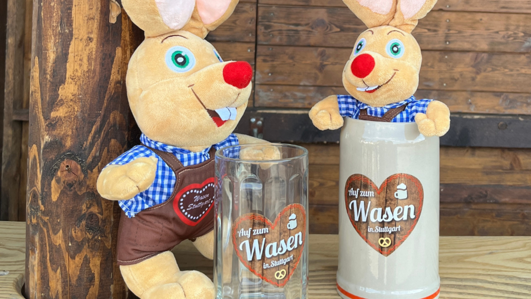 Zwei Plüsch-Hasen, einer mit einem Glas-Bierkrug in der Hand, der andere sitzt in einem Tonkrug