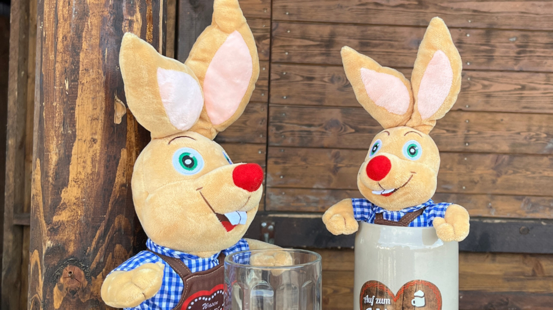 Zwei Plüsch-Hasen, einer mit einem Glas-Bierkrug in der Hand, der andere sitzt in einem Tonkrug