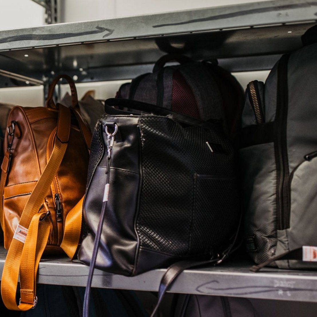Verschiedene Taschen und Rucksäcke in einem Regal.