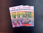 Drei Ausgaben der aktuellen Volksfestzeitung aufgefächert liegend.