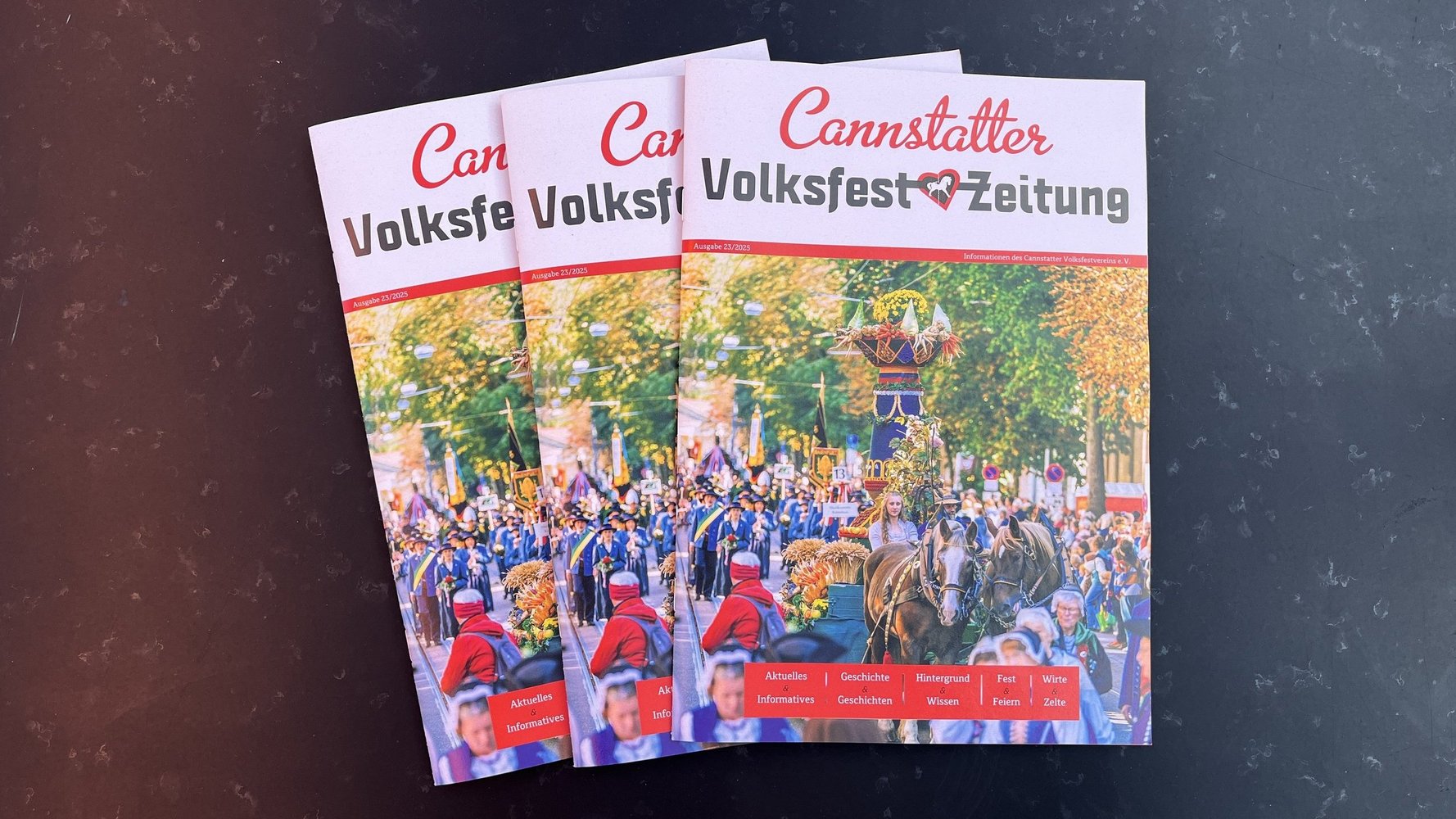 Drei aktuelle Ausgaben der Volksfestzeitung aufgefächert.