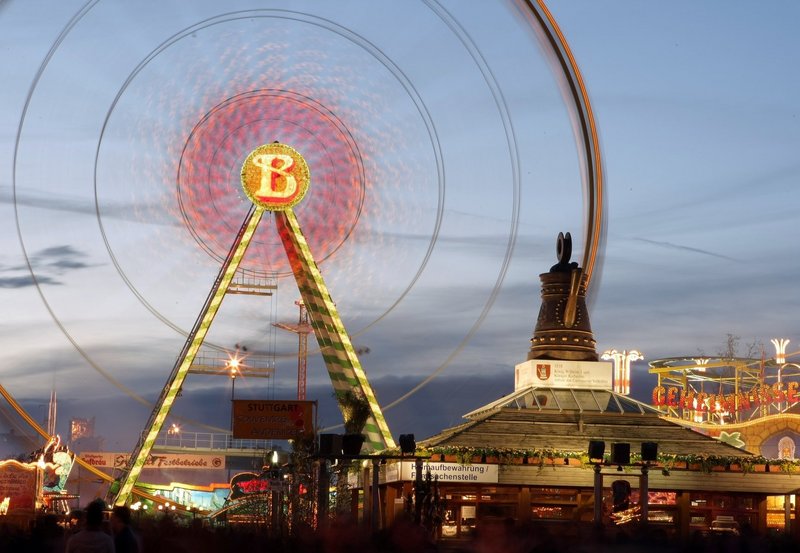 Foto von der Cannstatter Kanne bei Dämmerung. Im Hintergrund steht das beleuchtete Riesenrad
