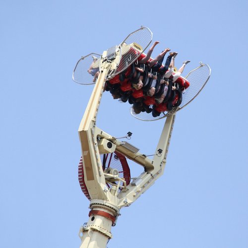 Menschen sitzen im Überkopf-Fahrgeschäft "Gladiator" und jubeln