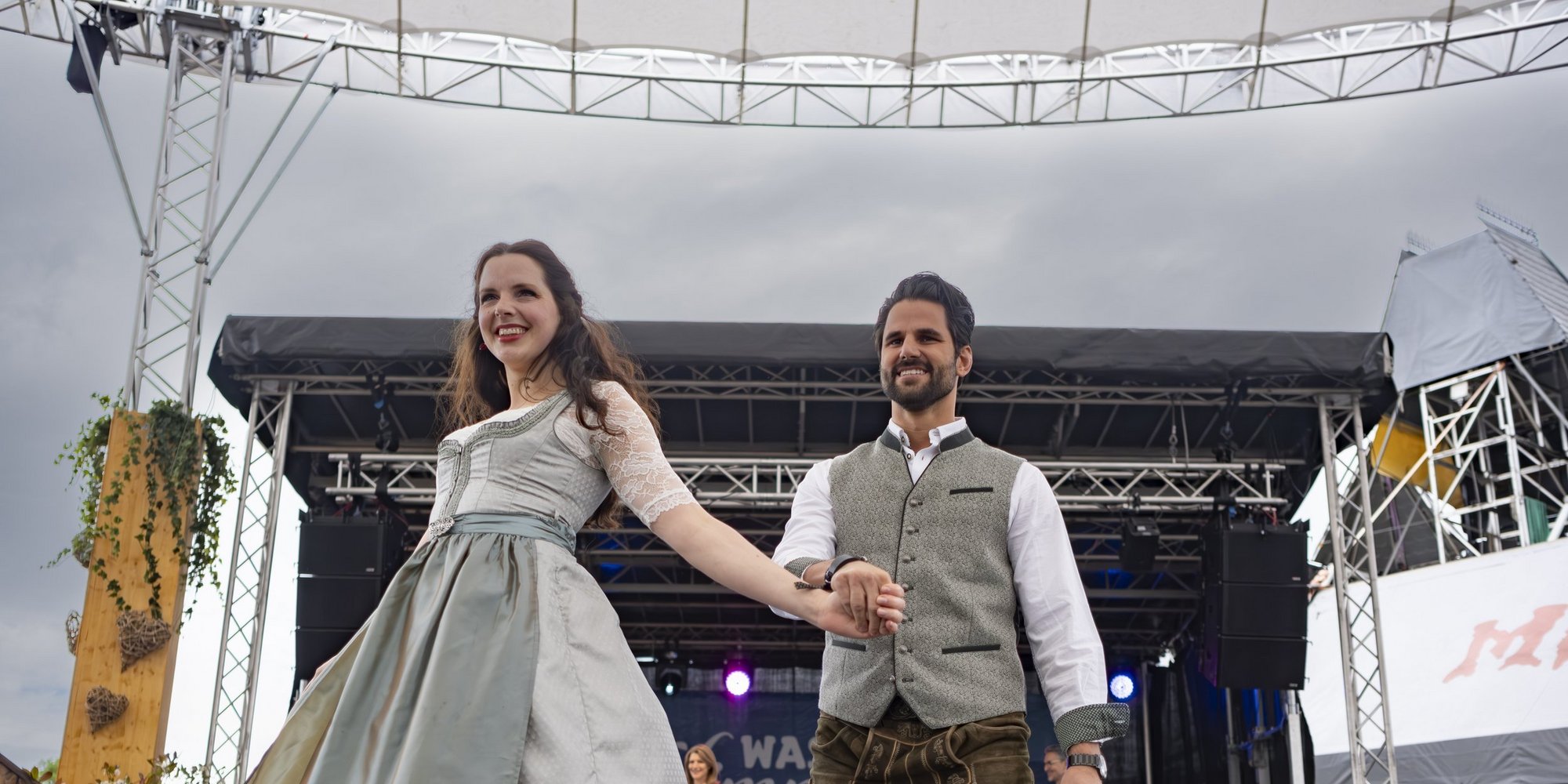 Eine Frau und ein Mann in Tracht laufen auf einer Bühne