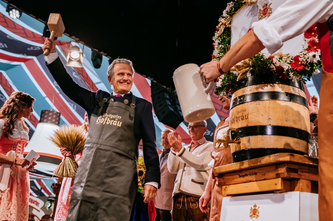 Oberbürgermeister Frank Nopper hebt den Ton-Krug nach dem erfolgreichen Fassanstich fröhlich in die Höhe.
